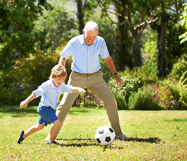 Grandfather playing football with his grandson